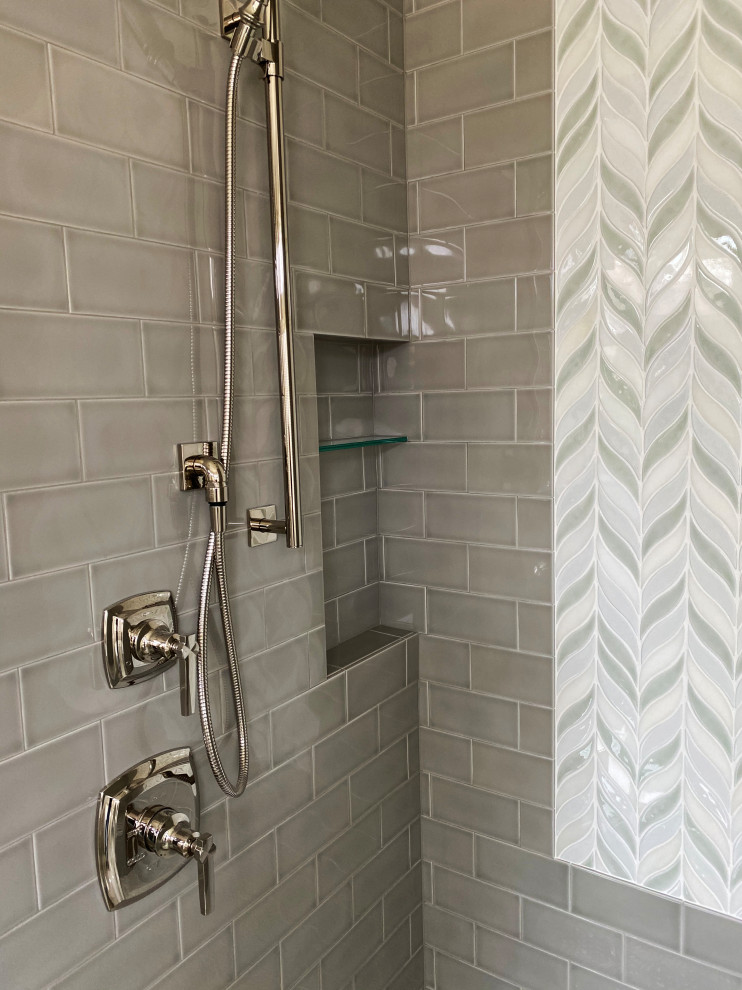 This is an example of a large traditional ensuite bathroom in Milwaukee with recessed-panel cabinets, white cabinets, a freestanding bath, a double shower, a two-piece toilet, metro tiles, porcelain flooring, a built-in sink, granite worktops, grey floors, a hinged door, multi-coloured worktops, a wall niche, a single sink and a built in vanity unit.