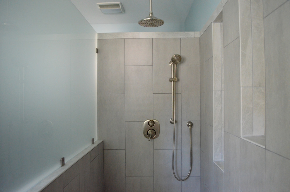 Maritimes Badezimmer En Suite mit Lamellenschränken, grauen Schränken, bodengleicher Dusche, Toilette mit Aufsatzspülkasten, beigen Fliesen, Keramikfliesen, blauer Wandfarbe, Keramikboden, Unterbauwaschbecken und Mineralwerkstoff-Waschtisch in Detroit