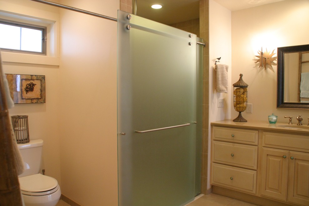 Immagine di una stanza da bagno con doccia stile marinaro di medie dimensioni con ante con bugna sagomata, ante bianche, doccia alcova, WC a due pezzi, piastrelle beige, piastrelle in ceramica, pareti beige, lavabo sottopiano, top in quarzo composito e porta doccia scorrevole