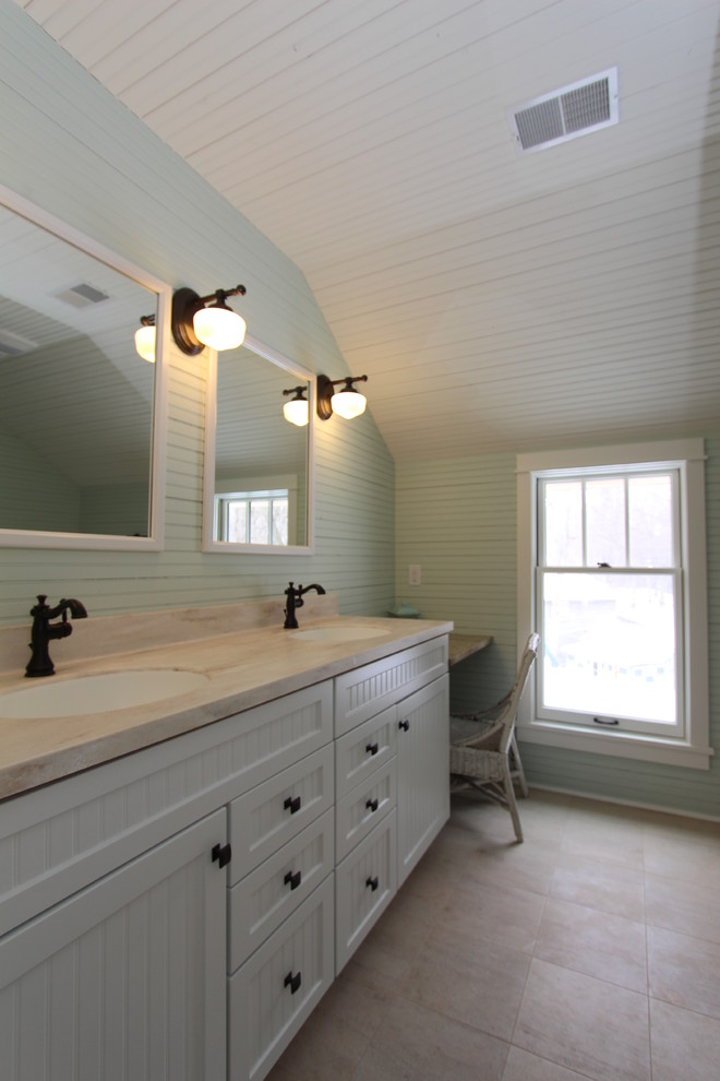 Photo of a nautical ensuite bathroom in Grand Rapids with white cabinets, a submerged sink, beaded cabinets, solid surface worktops, an alcove shower, a two-piece toilet, beige tiles, porcelain tiles, blue walls and porcelain flooring.
