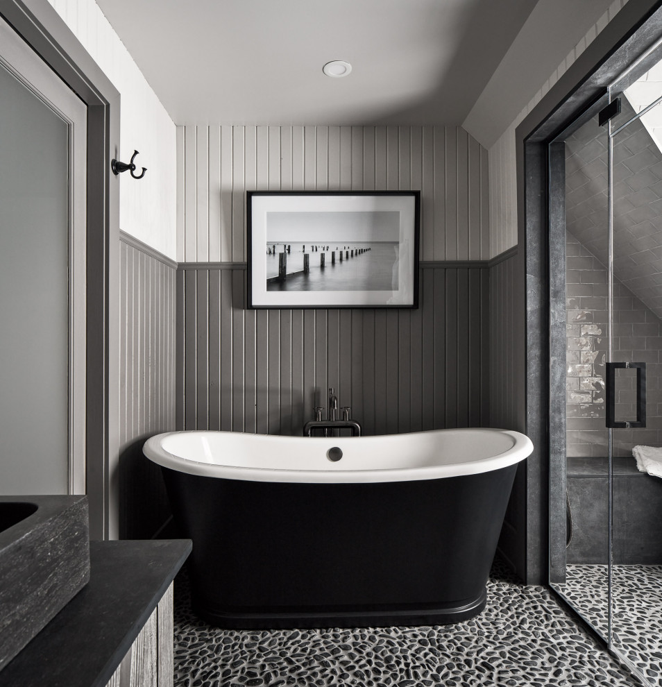 Источник вдохновения для домашнего уюта: ванная комната в стиле рустика с серыми фасадами, отдельно стоящей ванной, душем в нише, серой плиткой, плиткой кабанчик, серыми стенами, полом из галечной плитки, настольной раковиной, черным полом, черной столешницей, сиденьем для душа и панелями на стенах