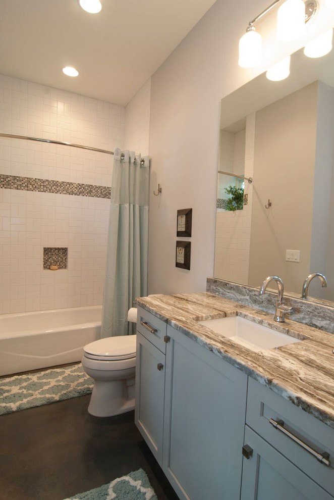 Klassisk inredning av ett mellanstort badrum med dusch, med skåp i shakerstil, grå skåp, ett badkar i en alkov, en dusch i en alkov, en toalettstol med hel cisternkåpa, vit kakel, tunnelbanekakel, grå väggar, mellanmörkt trägolv, ett undermonterad handfat, granitbänkskiva, brunt golv och dusch med duschdraperi
