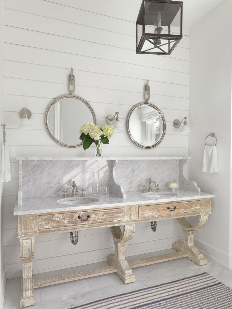 Ejemplo de cuarto de baño principal costero con puertas de armario de madera clara, paredes blancas, lavabo bajoencimera y armarios con paneles lisos