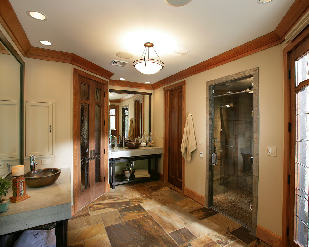 На фото: большая главная ванная комната в классическом стиле с открытыми фасадами, черными фасадами, душем в нише, раздельным унитазом, коричневой плиткой, серой плиткой, разноцветной плиткой, каменной плиткой, бежевыми стенами, полом из травертина, настольной раковиной и столешницей из бетона с