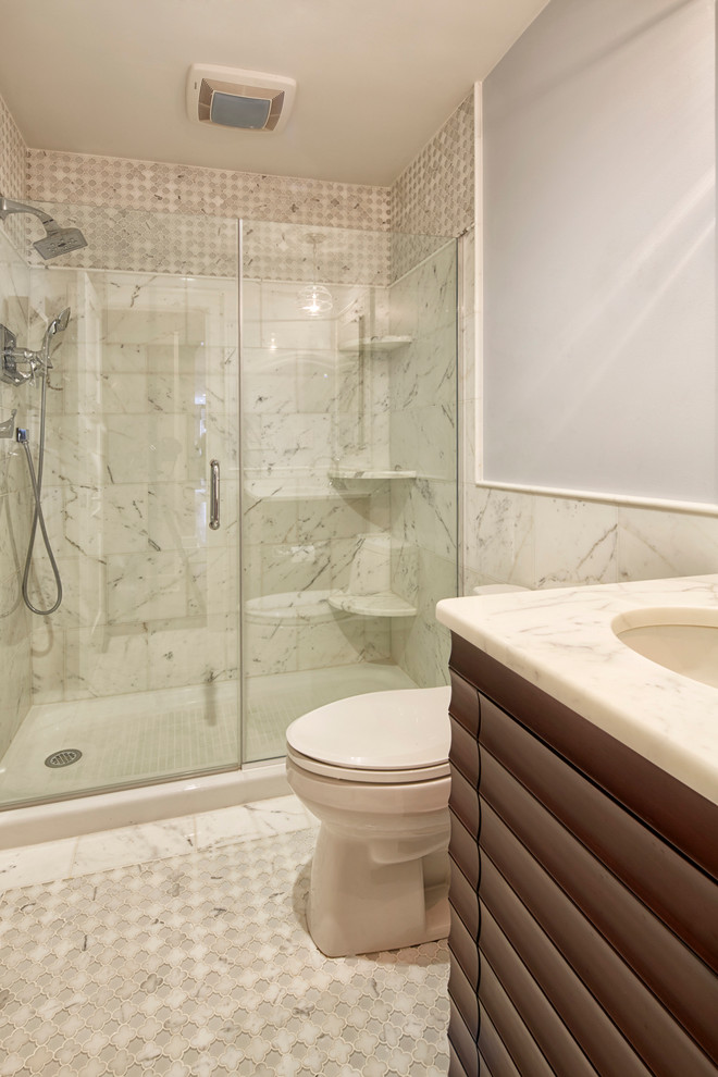 Immagine di una piccola stanza da bagno costiera con lavabo sottopiano, ante in legno bruno, top in marmo, WC monopezzo, piastrelle bianche, piastrelle in pietra, pareti blu e pavimento in marmo