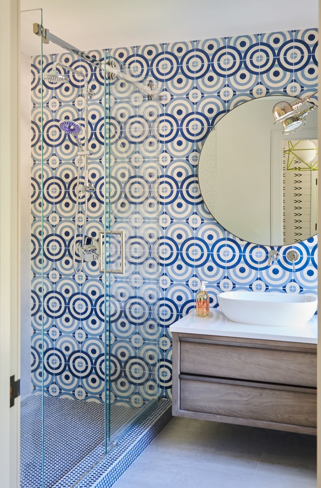 Inspiration for a large contemporary kids' blue tile and ceramic tile ceramic tile and gray floor sliding shower door remodel in New York with furniture-like cabinets, medium tone wood cabinets, blue walls, a vessel sink, quartz countertops and white countertops