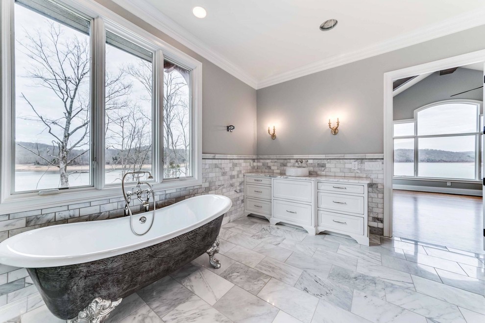 Inspiration for a large transitional master marble floor and white floor claw-foot bathtub remodel in Cleveland with recessed-panel cabinets, white cabinets, gray walls, a vessel sink and granite countertops