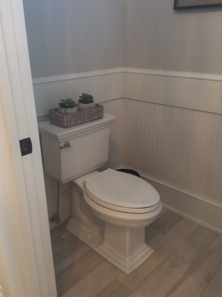 Aménagement d'un WC et toilettes classique de taille moyenne avec un carrelage blanc, des carreaux de béton, un mur gris et un sol en carrelage de porcelaine.