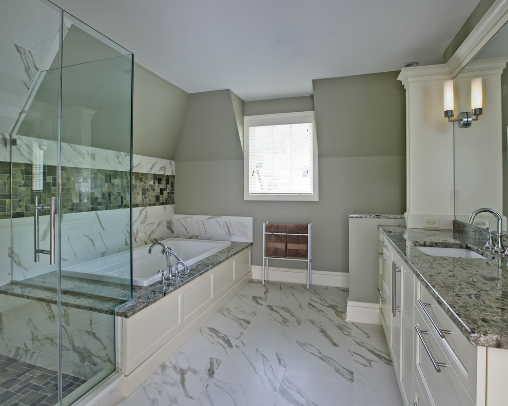 Modelo de cuarto de baño clásico con lavabo bajoencimera, armarios con paneles empotrados, puertas de armario blancas, bañera encastrada, ducha esquinera y baldosas y/o azulejos blancos