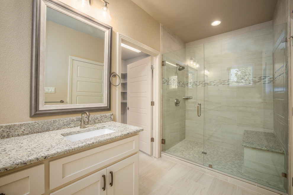 Exempel på ett stort rustikt flerfärgad flerfärgat badrum med dusch, med släta luckor, vita skåp, beige kakel, keramikplattor, ett undermonterad handfat, granitbänkskiva, dusch med gångjärnsdörr, en dubbeldusch, beige väggar, klinkergolv i keramik och vitt golv