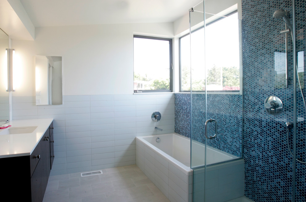 Inspiration pour une salle de bain design en bois foncé avec un lavabo encastré, un placard à porte plane, une douche d'angle, un carrelage bleu, mosaïque et une baignoire posée.
