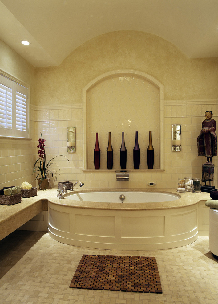На фото: ванная комната в классическом стиле с полновстраиваемой ванной и бежевой плиткой