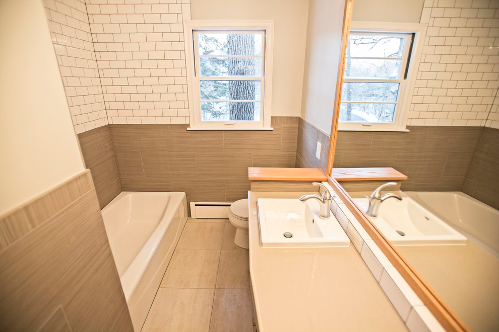 Пример оригинального дизайна: ванная комната в современном стиле с плоскими фасадами, светлыми деревянными фасадами, угловой ванной, угловым душем и белой плиткой