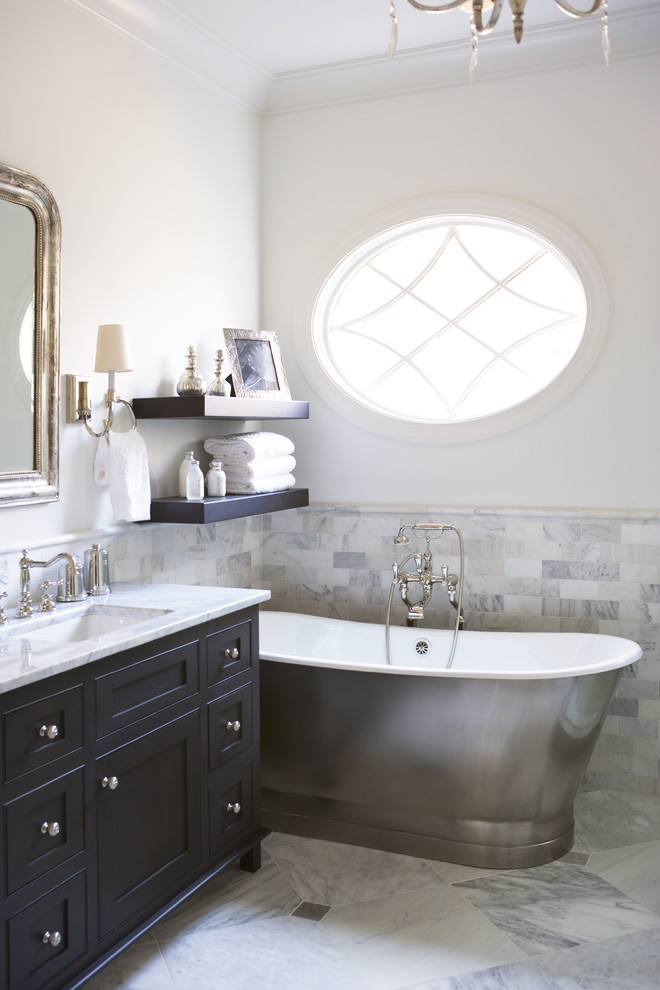 Freestanding bathtub - large traditional master subway tile and gray tile marble floor freestanding bathtub idea in Other with black cabinets, shaker cabinets, marble countertops, white walls and an undermount sink