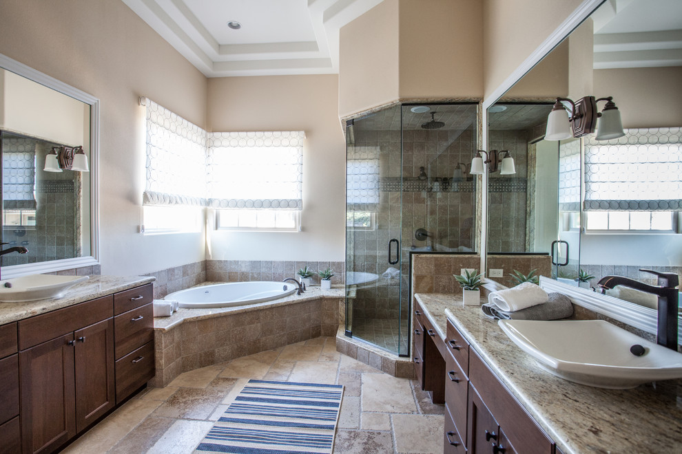 Mid-sized beach style master beige tile, brown tile and ceramic tile limestone floor, multicolored floor and double-sink bathroom photo in Las Vegas with shaker cabinets, dark wood cabinets, beige walls, a vessel sink, granite countertops, a hinged shower door and a one-piece toilet