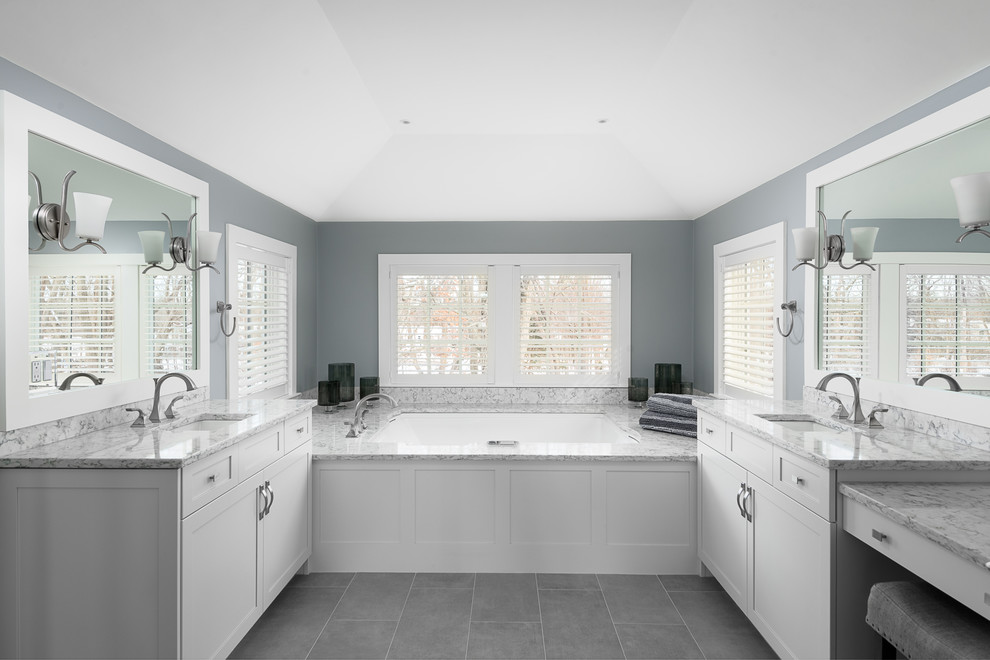 Inspiration for a large classic ensuite bathroom in Boston with shaker cabinets, white cabinets, a submerged bath, a corner shower, grey tiles, blue walls, porcelain flooring, a submerged sink, engineered stone worktops, grey floors and a hinged door.