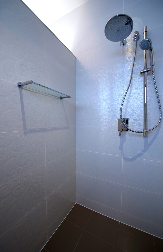Modelo de cuarto de baño actual con ducha abierta, baldosas y/o azulejos blancos, baldosas y/o azulejos de porcelana, paredes blancas y suelo de baldosas de porcelana