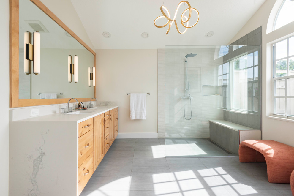 Example of a mid-sized trendy master gray floor, double-sink and vaulted ceiling bathroom design in Orlando with a built-in vanity, shaker cabinets, medium tone wood cabinets, beige walls, an undermount sink, white countertops and a niche