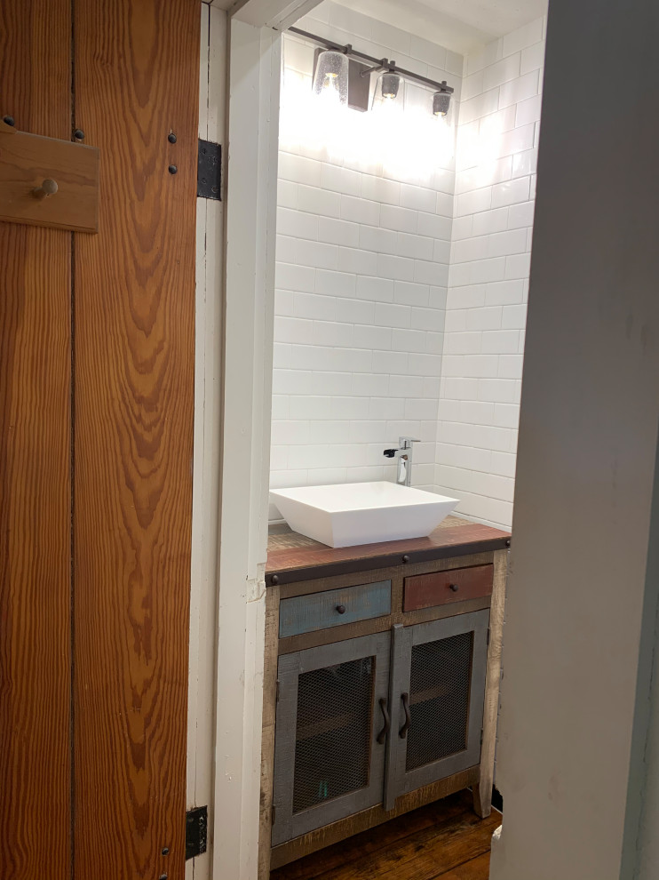 На фото: маленькая ванная комната в стиле неоклассика (современная классика) с фасадами цвета дерева среднего тона, душем в нише, раздельным унитазом, белой плиткой, плиткой кабанчик, белыми стенами, паркетным полом среднего тона, душевой кабиной, настольной раковиной, столешницей из цинка, коричневым полом, душем с распашными дверями, серой столешницей, сиденьем для душа, тумбой под одну раковину и напольной тумбой для на участке и в саду