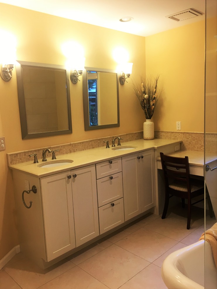 Photo of a medium sized traditional ensuite bathroom in Grand Rapids with beaded cabinets, white cabinets, a freestanding bath, a built-in shower, a one-piece toilet, beige tiles, porcelain tiles, yellow walls, porcelain flooring, an integrated sink and quartz worktops.