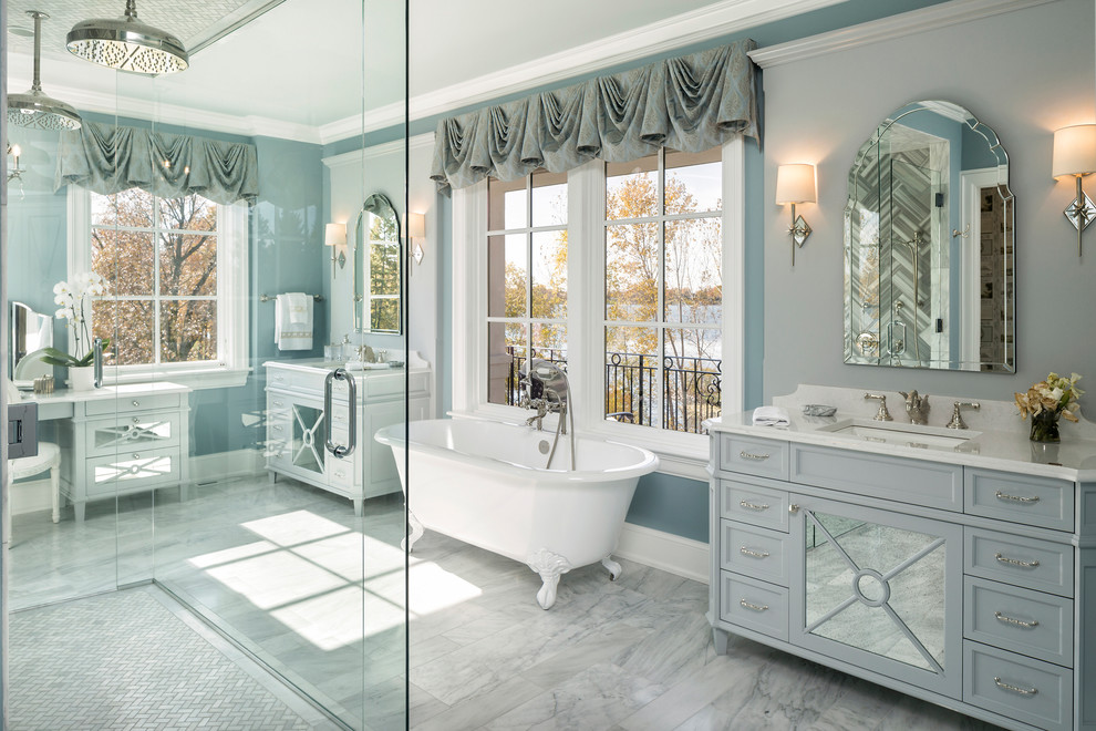 This is an example of a large traditional ensuite bathroom in Minneapolis with recessed-panel cabinets, grey cabinets, a freestanding bath, an alcove shower, grey tiles, ceramic tiles, blue walls, marble flooring, a submerged sink, marble worktops, white floors and a hinged door.