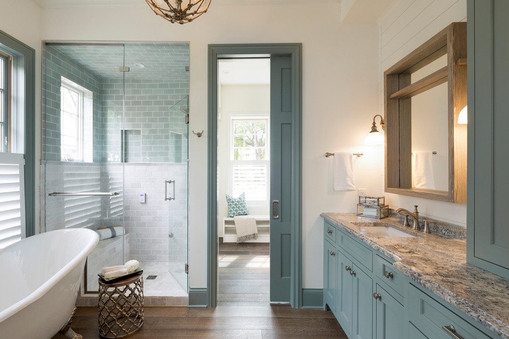 Bathroom - coastal master multicolored tile and stone tile medium tone wood floor and brown floor bathroom idea in Minneapolis with recessed-panel cabinets, blue cabinets, white walls, an undermount sink, quartzite countertops and a hinged shower door
