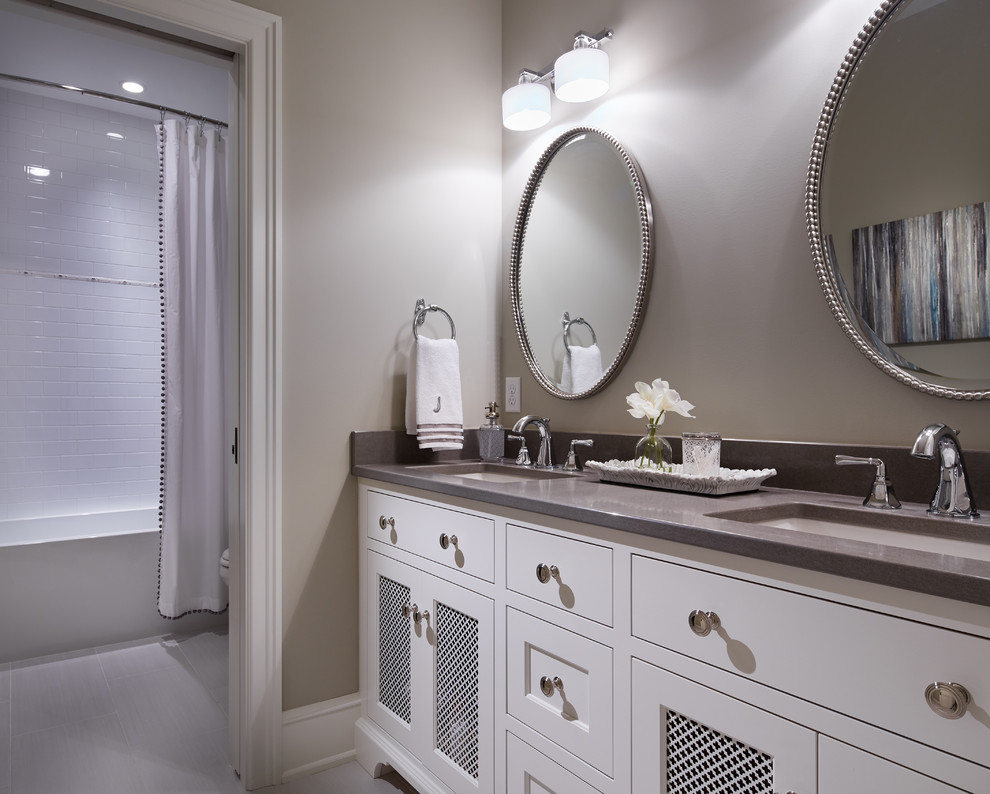 Bathroom - mid-sized transitional white tile and ceramic tile porcelain tile bathroom idea in Minneapolis with recessed-panel cabinets, white cabinets, a two-piece toilet, beige walls and an undermount sink