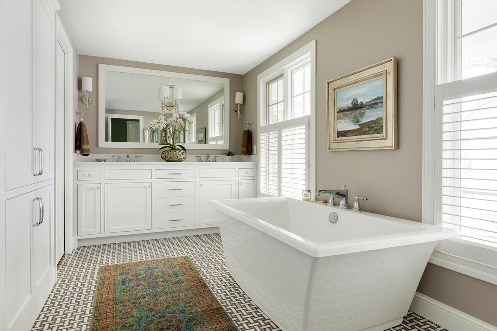 На фото: главная ванная комната в морском стиле с фасадами в стиле шейкер, белыми фасадами, отдельно стоящей ванной, бежевыми стенами, разноцветным полом и зеркалом с подсветкой с