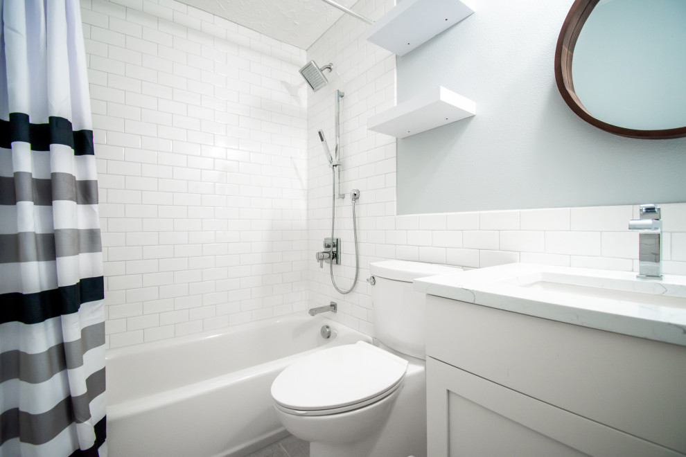 Exemple d'une petite salle de bain principale tendance avec un placard à porte plane, des portes de placard blanches, une baignoire en alcôve, un combiné douche/baignoire, WC séparés, un carrelage blanc, des carreaux de céramique, un mur bleu, un sol en bois brun, un lavabo encastré, un plan de toilette en quartz, un sol marron, une cabine de douche avec un rideau et un plan de toilette blanc.