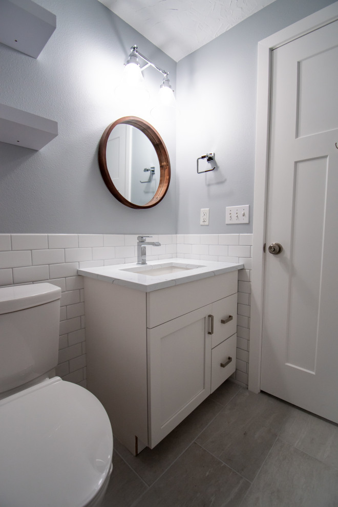 ポートランドにある高級な小さなコンテンポラリースタイルのおしゃれなマスターバスルーム (フラットパネル扉のキャビネット、白いキャビネット、アルコーブ型浴槽、シャワー付き浴槽	、分離型トイレ、白いタイル、セラミックタイル、青い壁、無垢フローリング、アンダーカウンター洗面器、珪岩の洗面台、茶色い床、シャワーカーテン、白い洗面カウンター) の写真