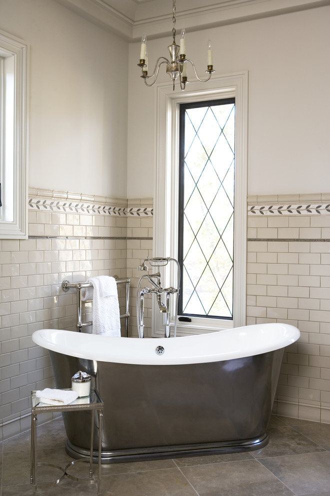 Modelo de cuarto de baño principal tradicional renovado grande con bañera exenta, baldosas y/o azulejos de cemento, baldosas y/o azulejos beige, paredes blancas y suelo de piedra caliza