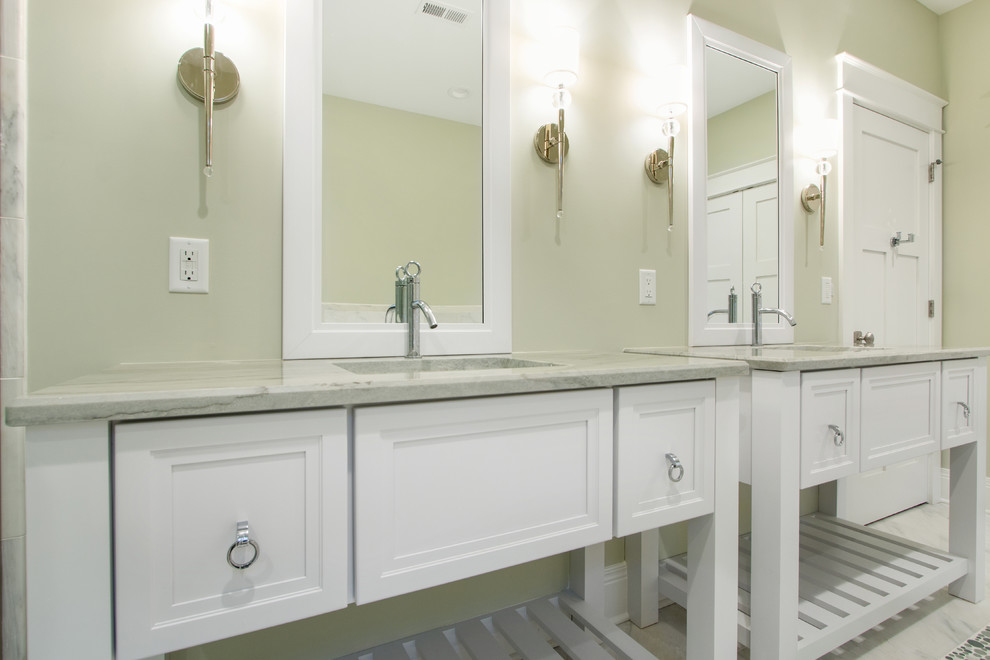 Cette image montre une douche en alcôve traditionnelle de taille moyenne avec un placard avec porte à panneau encastré, des portes de placard blanches, WC à poser, un carrelage gris, mosaïque, un mur gris, un sol en galet, un lavabo encastré et un plan de toilette en quartz modifié.