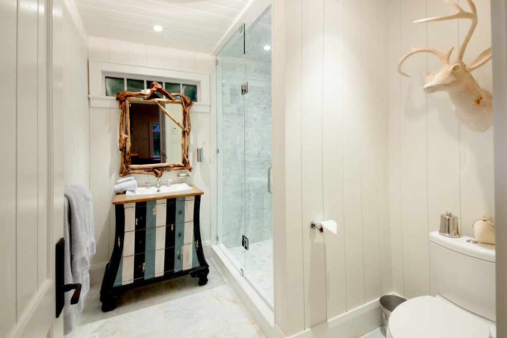 Réalisation d'une salle de bain chalet de taille moyenne avec un placard en trompe-l'oeil, WC séparés, un carrelage gris, du carrelage en marbre, un mur blanc, un lavabo posé, un plan de toilette en bois, un sol gris et une cabine de douche à porte battante.