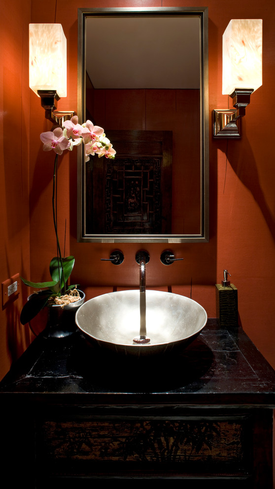 Kleines Asiatisches Duschbad mit Aufsatzwaschbecken, verzierten Schränken, schwarzen Schränken, Toilette mit Aufsatzspülkasten, roter Wandfarbe und Kalkstein in Chicago