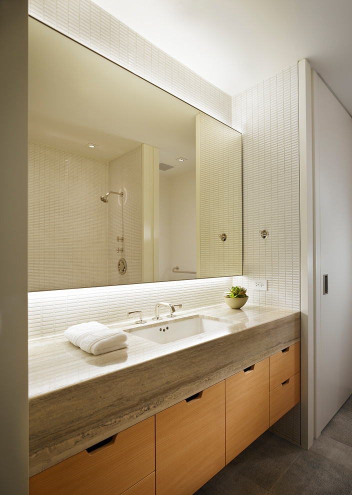 Immagine di una stanza da bagno design con ante lisce, ante in legno scuro, piastrelle bianche, piastrelle a mosaico, lavabo sottopiano, pavimento grigio e top grigio