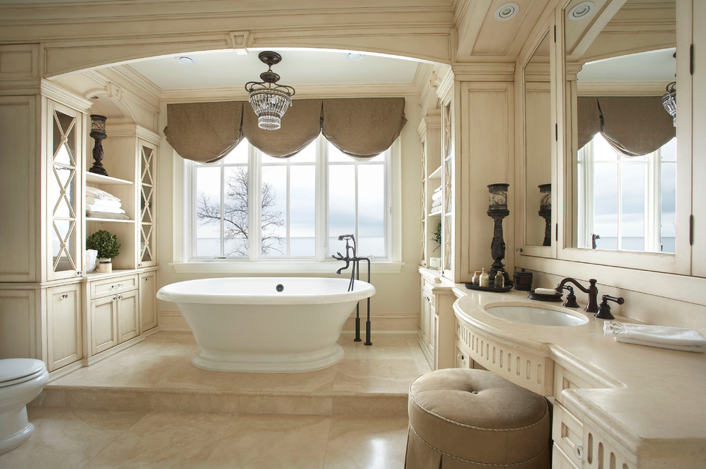Idéer för stora vintage en-suite badrum, med luckor med infälld panel, skåp i slitet trä, ett fristående badkar, beige kakel och ett undermonterad handfat