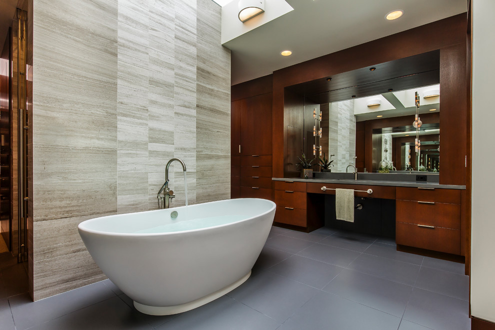 На фото: большая главная ванная комната в современном стиле с плоскими фасадами, темными деревянными фасадами, отдельно стоящей ванной, бежевой плиткой, керамогранитной плиткой, бежевыми стенами, бетонным полом, врезной раковиной и серым полом с