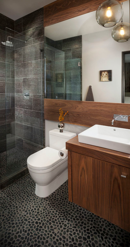 This is an example of a rustic bathroom in San Francisco with a vessel sink, flat-panel cabinets, dark wood cabinets, wooden worktops, a walk-in shower, grey tiles, an open shower and brown worktops.
