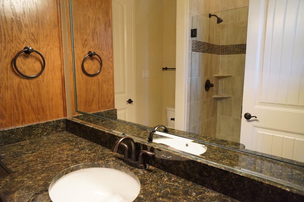 Foto på ett mellanstort lantligt badrum för barn, med luckor med upphöjd panel, skåp i mellenmörkt trä, granitbänkskiva, en dusch i en alkov, beige kakel, porslinskakel och klinkergolv i porslin