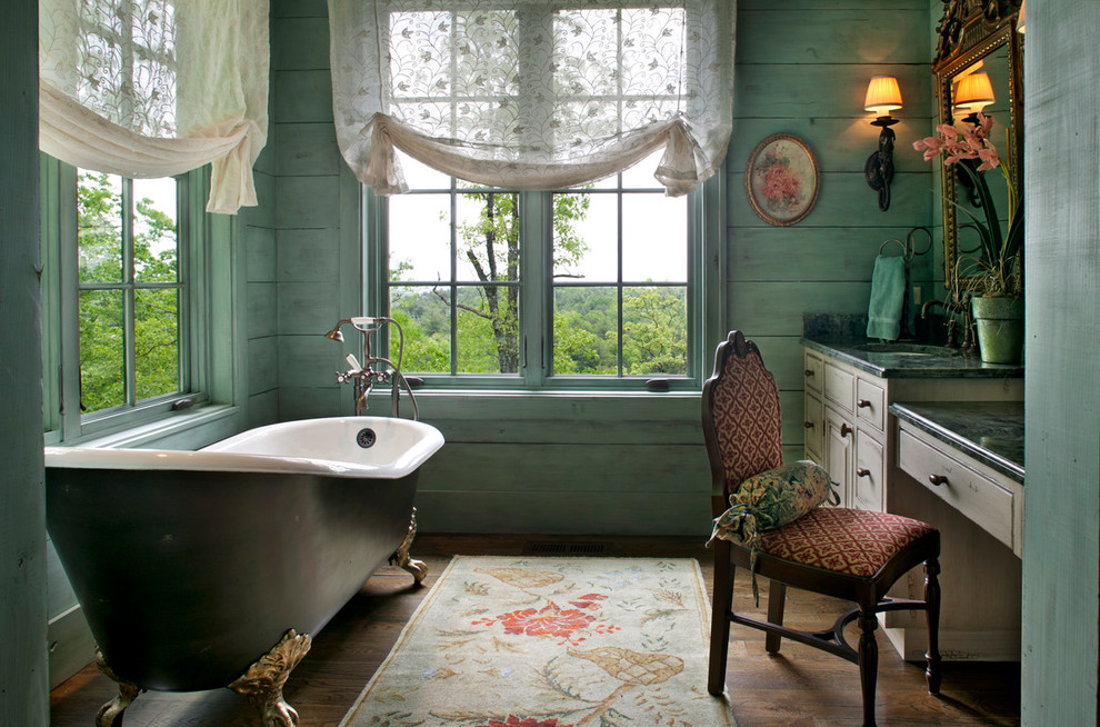 Ornate claw-foot bathtub photo in Other with raised-panel cabinets, blue walls and green countertops