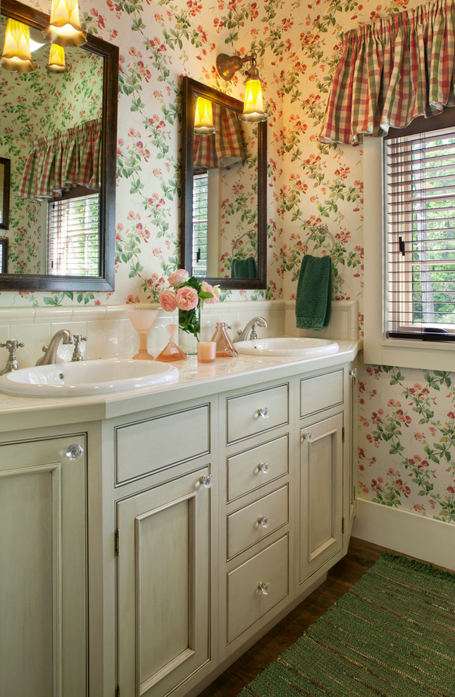 Cette image montre une salle de bain traditionnelle avec un lavabo posé, un placard avec porte à panneau encastré, des portes de placards vertess, un plan de toilette en carrelage, un carrelage beige et un mur multicolore.