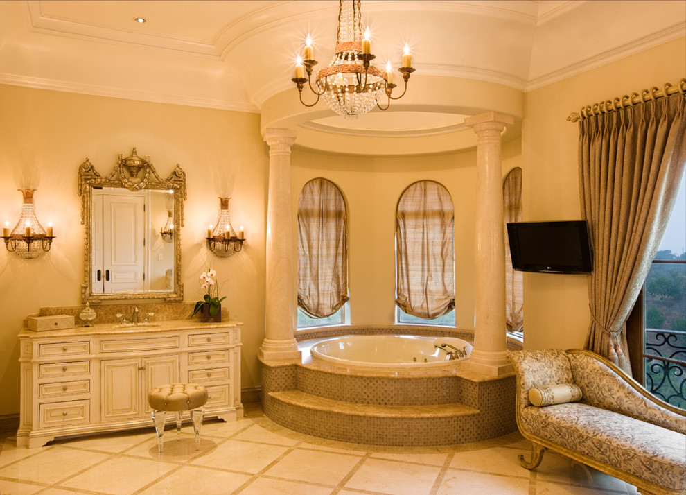 Ispirazione per una stanza da bagno padronale mediterranea di medie dimensioni con ante con bugna sagomata, ante bianche, vasca da incasso, pareti beige, lavabo sottopiano e top in granito