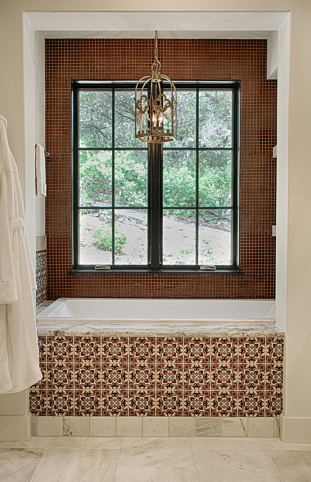 オースティンにある地中海スタイルのおしゃれなマスターバスルーム (ドロップイン型浴槽、赤い壁、ベージュの床) の写真