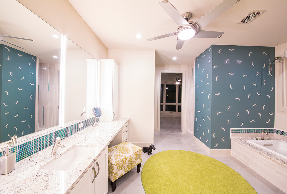 Inredning av ett modernt mellanstort en-suite badrum, med vita skåp, granitbänkskiva, ett platsbyggt badkar, en toalettstol med separat cisternkåpa, blå kakel, stickkakel, vita väggar, skåp i shakerstil, betonggolv och ett undermonterad handfat