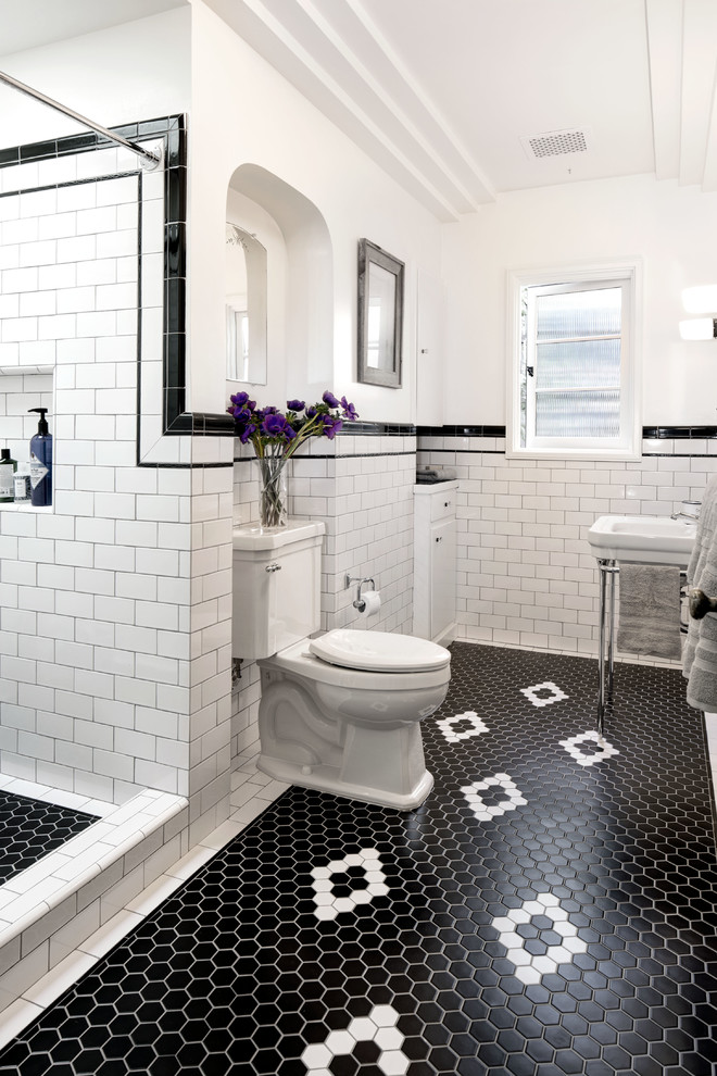 ロサンゼルスにある中くらいなヴィクトリアン調のおしゃれな浴室 (アルコーブ型シャワー、分離型トイレ、モノトーンのタイル、セラミックタイル、白い壁、セラミックタイルの床、ペデスタルシンク、黒い床、シャワーカーテン) の写真
