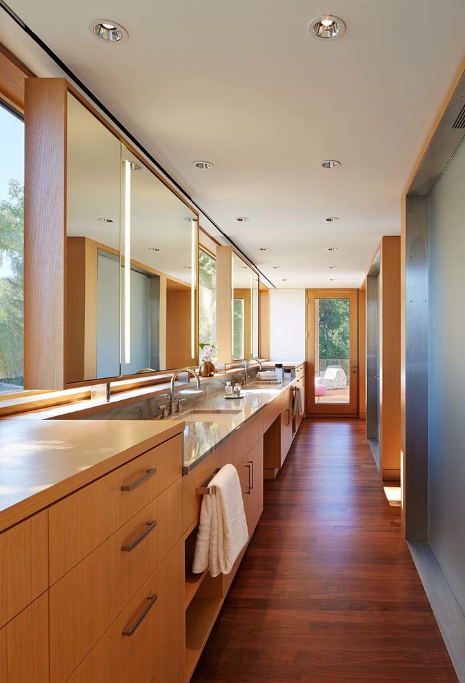 Imagen de cuarto de baño principal contemporáneo con armarios con paneles lisos, puertas de armario de madera clara, lavabo bajoencimera, encimera de mármol y suelo de madera en tonos medios