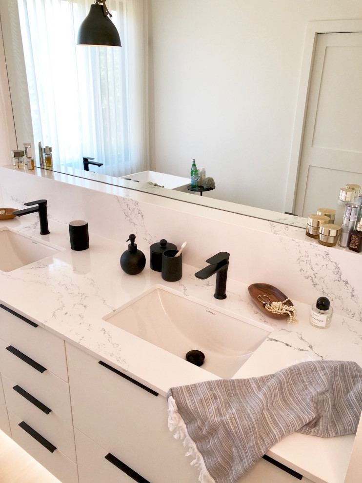 Bild på ett stort skandinaviskt vit vitt en-suite badrum, med släta luckor, vita skåp, ett fristående badkar, våtrum, en toalettstol med separat cisternkåpa, vita väggar, ett undermonterad handfat, bänkskiva i kvartsit och dusch med gångjärnsdörr