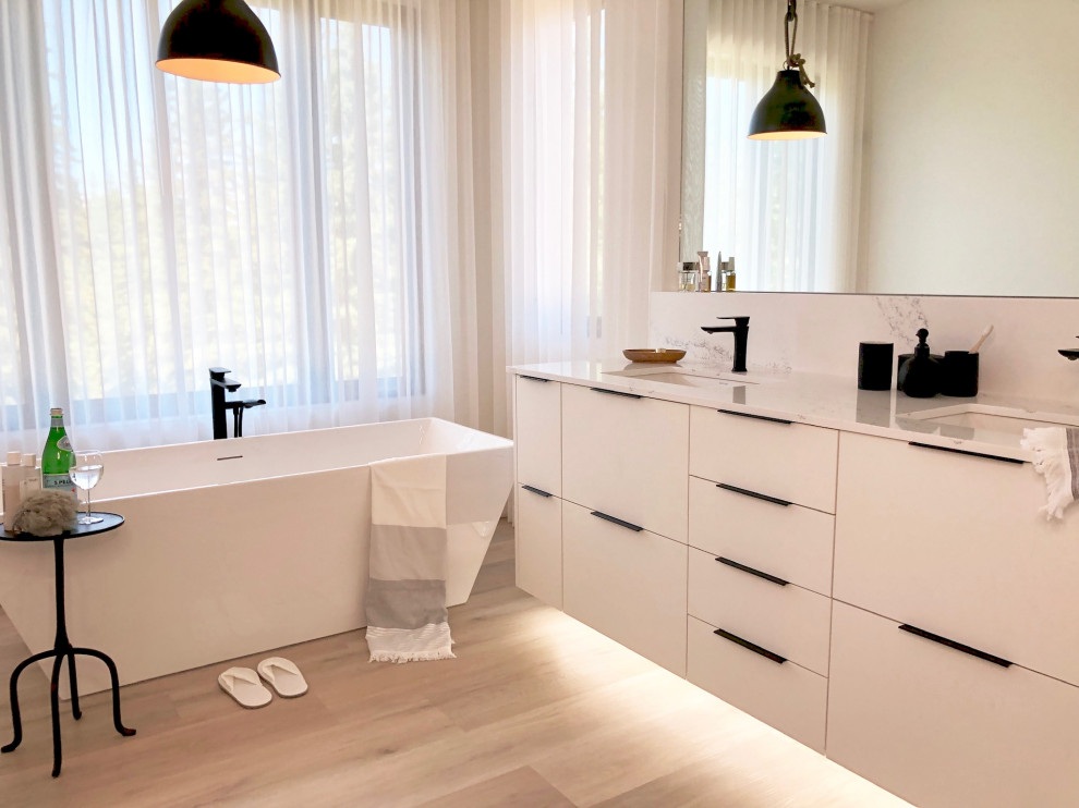 Inredning av ett nordiskt stort vit vitt en-suite badrum, med släta luckor, vita skåp, ett fristående badkar, våtrum, en toalettstol med separat cisternkåpa, vita väggar, ett undermonterad handfat, bänkskiva i kvartsit och dusch med gångjärnsdörr