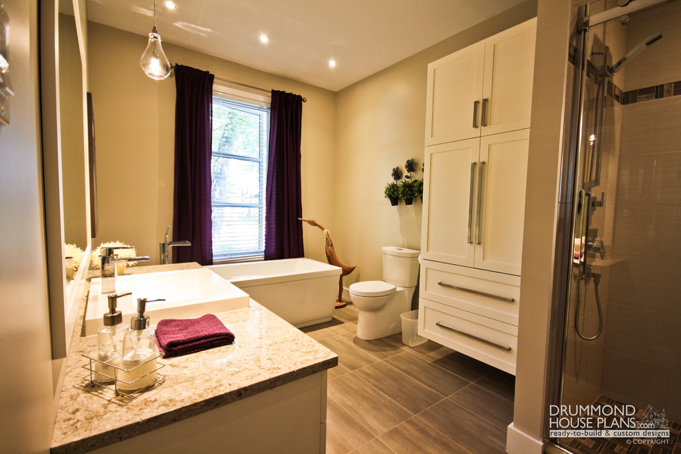 Inredning av ett minimalistiskt mellanstort en-suite badrum, med ett nedsänkt handfat, möbel-liknande, vita skåp, granitbänkskiva, ett fristående badkar, en hörndusch, en toalettstol med hel cisternkåpa, grå kakel, keramikplattor, beige väggar och klinkergolv i keramik