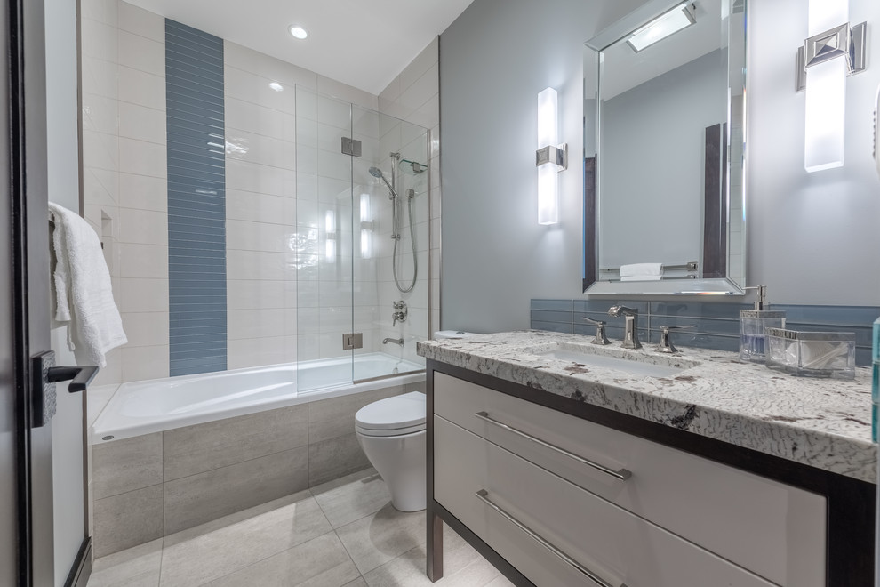 Immagine di una stanza da bagno american style con vasca ad alcova, vasca/doccia, piastrelle bianche, piastrelle in ceramica, pavimento in gres porcellanato, pavimento grigio e doccia aperta